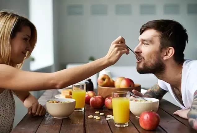 seorang wanita memberi makan seorang pria dengan kacang untuk meningkatkan potensi